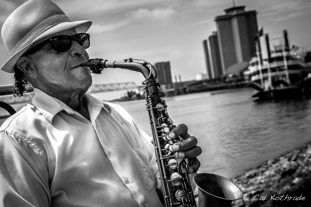 Saxophone player T.S. Lark along banks of Mississippi river in NOLA.